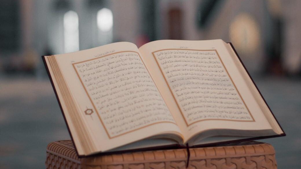 opened religious book on stone desk in mosque backyard